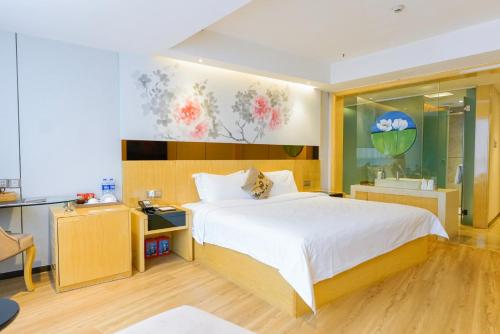 a bedroom with a large bed and a desk at Paco Hotel Tuanyida Metro Guangzhou -Free ShuttleBus for Canton Fair in Guangzhou