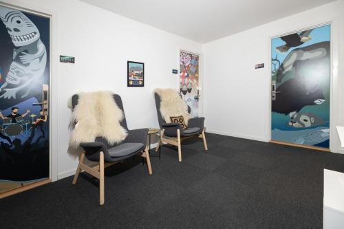 a waiting room with two chairs and paintings on the walls at Kulukis Downtown Hostel in Nuuk