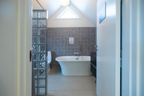uma casa de banho com uma banheira e uma clarabóia em Kulukis Downtown Hostel em Nuuk