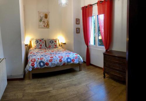 BaleyssaguesにあるGite Bacchusのベッドルーム1室(ベッド1台付)、赤いカーテン付きの窓が備わります。