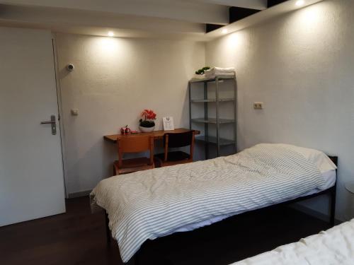 1 dormitorio con 1 cama y mesa con escritorio en Pension Het Hoefijzer en Buren