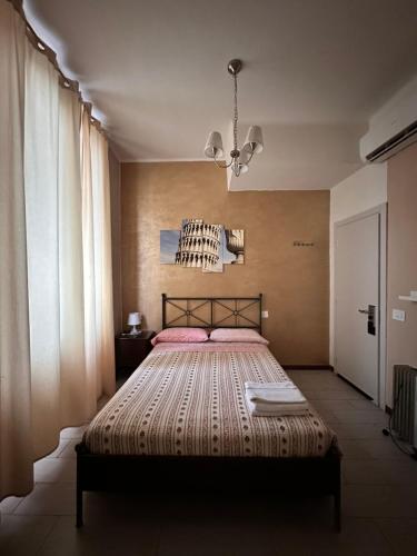 una camera con letto e lampadario a braccio di Locanda San Lorenzo a Firenze