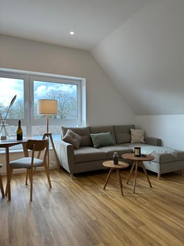 a living room with a couch and two tables at Dümmerland Apartments in Lemförde