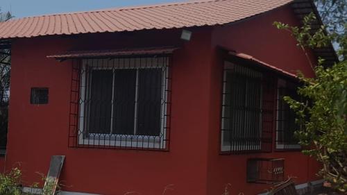 een rood huis met twee ramen en een rood dak bij Butaliaji's House in Khopoli