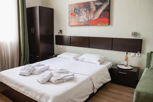 a bedroom with a bed with white towels on it at Hotel Ilisia in Thessaloniki