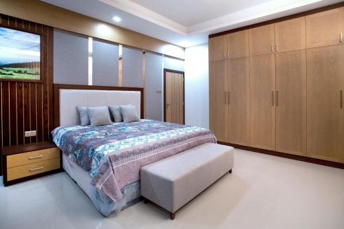 1 dormitorio con 1 cama y armarios de madera en Elite Villa, en Duqm