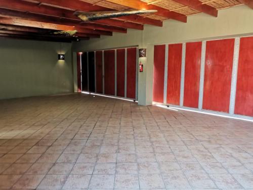 an empty room with red doors and a tile floor at Dai Heka Guest House in Strand