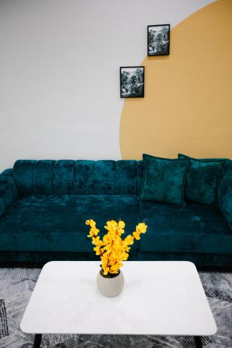 a living room with a white table and a green couch at Andor Luxury Hotel & Duplex in Durrës