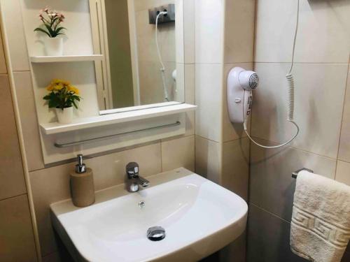 a bathroom with a sink and a mirror and flowers at Apartamento Andaluz CARMA in Torrox Costa