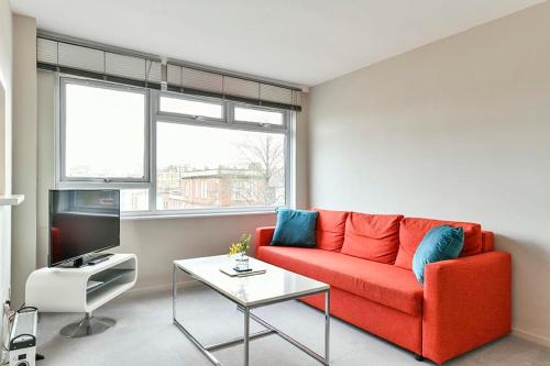 sala de estar con sofá rojo y mesa en No 15 Brompton cross, en Londres