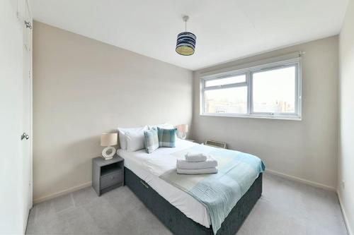 1 dormitorio blanco con 1 cama grande y ventana en No 15 Brompton cross, en Londres