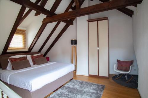 une chambre avec un lit blanc et une chaise dans l'établissement L'Or - Typical Alsacian apartment in Strasbourg, à Strasbourg
