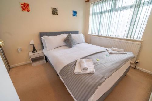 ein Schlafzimmer mit einem Bett mit Handtüchern darauf in der Unterkunft Pass the Keys Stylish 3 bedroom home with free parking in Nottingham