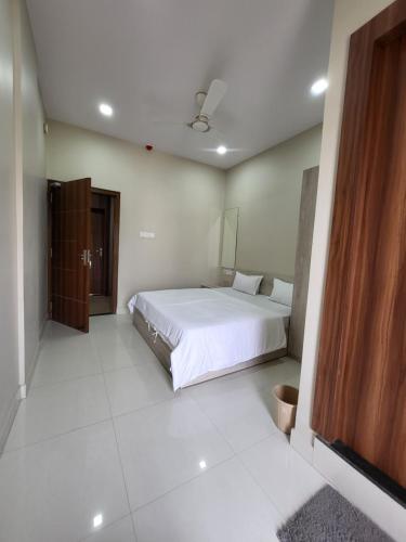 SASA INN في جمشيدبور: غرفة نوم مع سرير أبيض كبير في غرفة