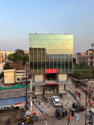 un gran edificio de cristal con coches aparcados en un aparcamiento en SASA INN, en Jamshedpur