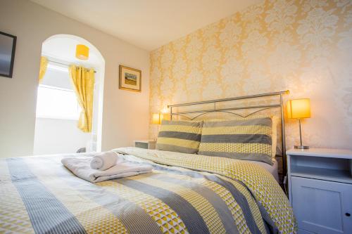 Un dormitorio con una cama con una toalla. en Tilly Cottage, DurhamDales en Bishop Auckland