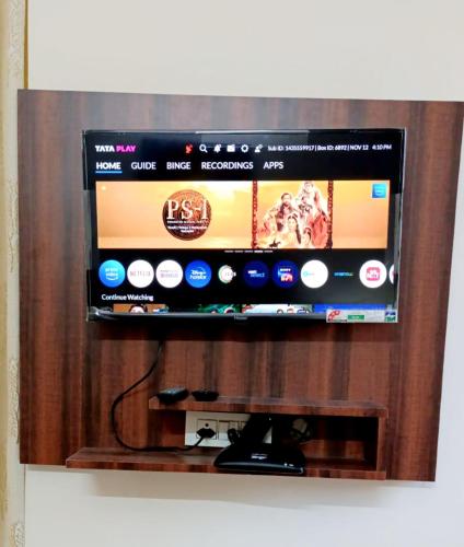 a flat screen tv sitting on a wooden stand at Yogvan Luxury 1BHK Apartments Tapovan Rishikesh in Rishīkesh