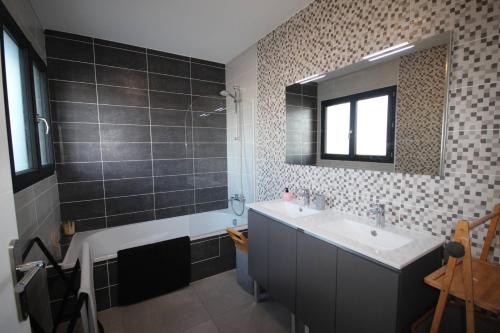 uma casa de banho com um lavatório e um espelho em Belle villa contemporaine climatisee, piscine privee, 6 - 8 couchages, 3 chambres, wifi, à 3 km de la plage -LXDALI25B em Portiragnes