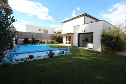 une maison avec une piscine dans une cour dans l'établissement Belle villa contemporaine climatisee, piscine privee, 6 - 8 couchages, 3 chambres, wifi, à 3 km de la plage -LXDALI25B, à Portiragnes