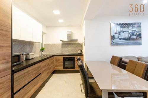 eine Küche und ein Esszimmer mit einem Tisch in der Unterkunft Spacious 3BR designer home just off the promenade by 360 Estates in St Paul's Bay