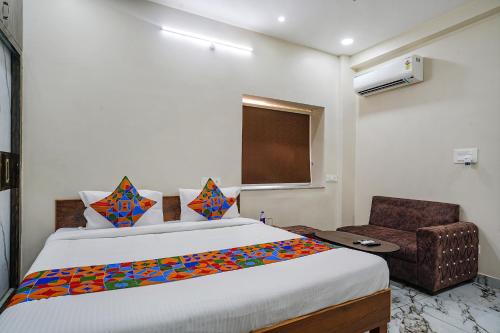 a bedroom with a large bed and a chair at FabHotel Perams Grand Inn in Kondapur
