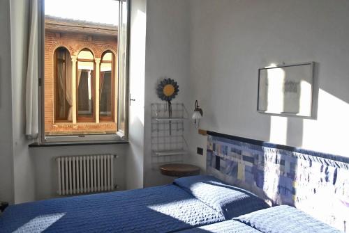 a bedroom with a blue bed and a window at Rubino Apartment in Levanto