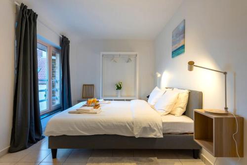 een slaapkamer met een groot bed en een raam bij Jette Expo Duplex Residence in Brussel