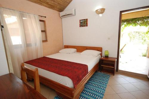 a bedroom with a bed and a large window at Fagapa Lodge in Guilor