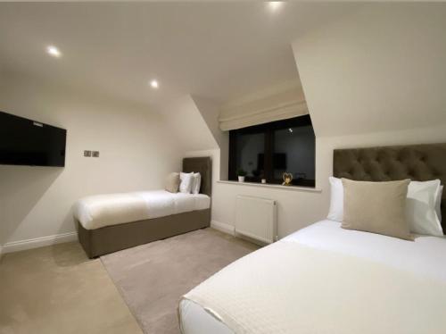 a bedroom with two beds and a flat screen tv at The Pines in Saint Leonards