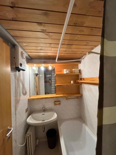 ein kleines Bad mit einem Waschbecken und einer Badewanne in der Unterkunft Trilocale sulle piste con vista sulla ValdiSole in Marilleva