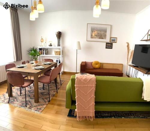 a living room with a green couch and a table at Le Pink Lady Avenue de champagne in Épernay