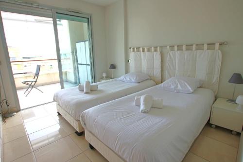カンヌにあるFully equipped apartment with large terrace lounge areaの海の景色を望むベッドルーム1室(ベッド2台付)