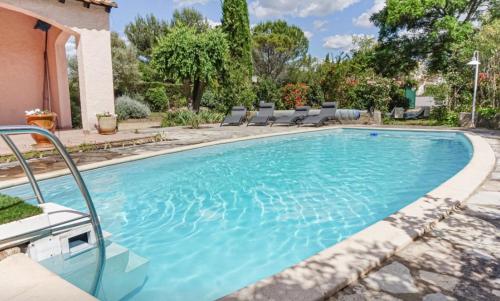 einen Pool mit Stühlen vor einem Haus in der Unterkunft Villa impressionniste * Jardin* Clim * Piscine * in Les Matelles