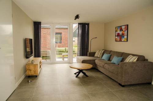 a living room with a couch and a table at Bungalow 70 op Recreatiepark De Wielen in Sint Maarten