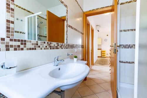 ein Bad mit einem Waschbecken und einem Spiegel in der Unterkunft Appartamento Pinolo Trilo INT 9 - MyHo Casa in Alba Adriatica