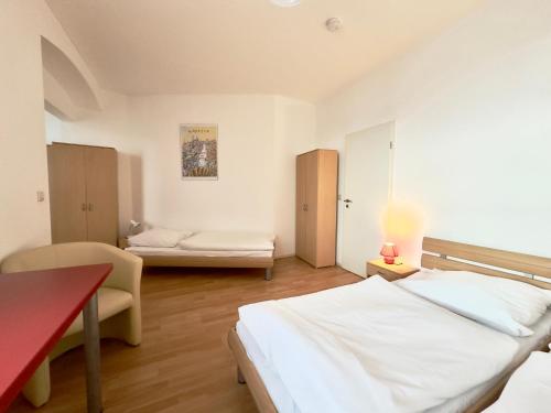 a bedroom with a bed and a table and a couch at Picobello Pension in Görlitz