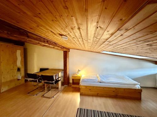 a bedroom with a bed and a wooden ceiling at Picobello Pension in Görlitz