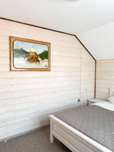 łóżko w pokoju z obrazem na ścianie w obiekcie Софія w mieście Jasina