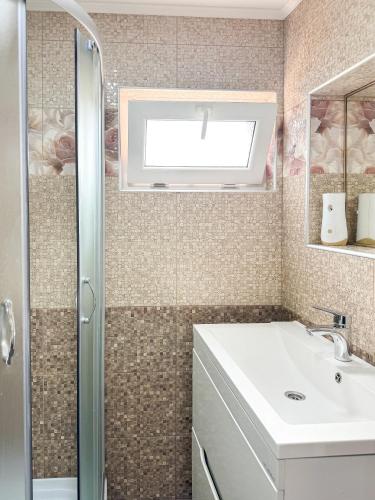 W łazience znajduje się umywalka i prysznic. w obiekcie Софія w mieście Jasina