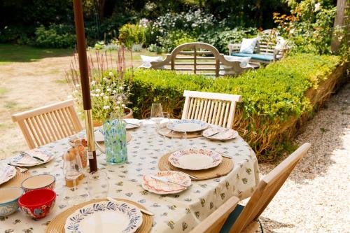 a table with plates and dishes on top of it at Newly Renovated Cottage 150m from Waterfront in Bosham