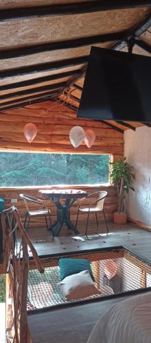 a room with a table and chairs on a patio at Cabaña en la calera el Pinar in La Calera