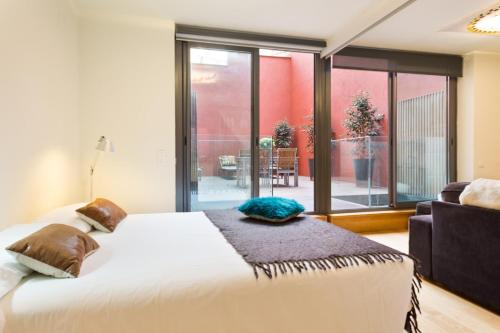a bedroom with a bed and a large window at Barcino Inversions - Fully equipped apartments near the Beach with shared pool in Barcelona