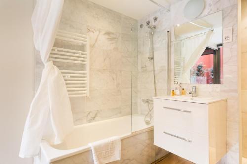 a bathroom with a shower and a tub and a sink at Barcino Inversions - Fully equipped apartments near the Beach with shared pool in Barcelona