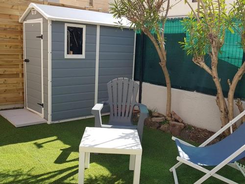 une terrasse avec une chaise, une table et une maison dans l'établissement Appartement 3 pièces climatisé, terrasse, 6 couchages, parking privé, animaux admis - FR-1-326-673, à Marseillan