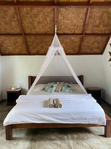 a bedroom with a bed with two towels on it at Villa Paradise - Bukit Lawang in Bukit Lawang