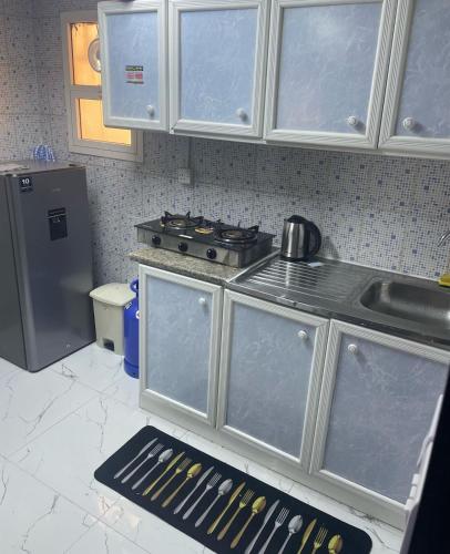 a kitchen with a stove and a refrigerator at Your private hotel oasis awaits! in Abu Dhabi