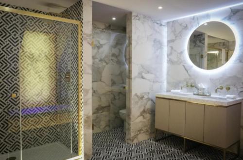 uma casa de banho com um chuveiro, um lavatório e um espelho. em Beaufort Hotel em Inverness