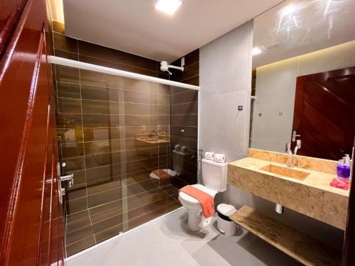 a bathroom with a toilet and a sink and a shower at Pousada Villa Marceneiro Beach in Passo de Camarajibe