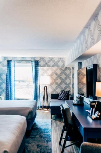 a hotel room with two beds and a desk at Salem Waterfront Hotel & Suites in Salem