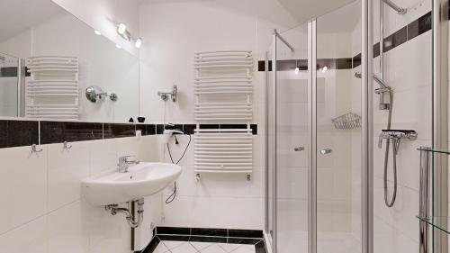 a white bathroom with a sink and a shower at Residenz Prorer Wiek in Binz